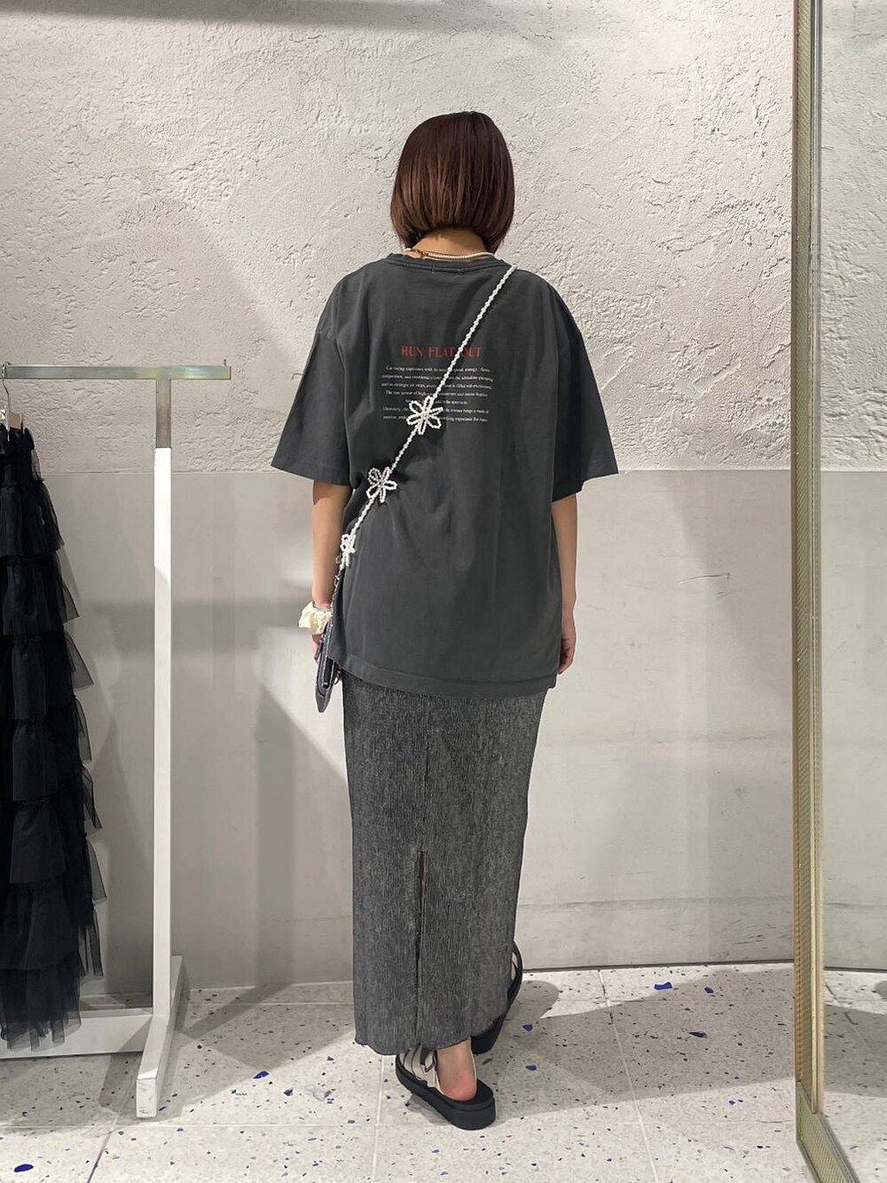 ホワイト系のスニーカー、グレー系のTシャツ/カットソー、ブラック系のスカートを着用したレディースの夏コーディネートの3枚目の写真