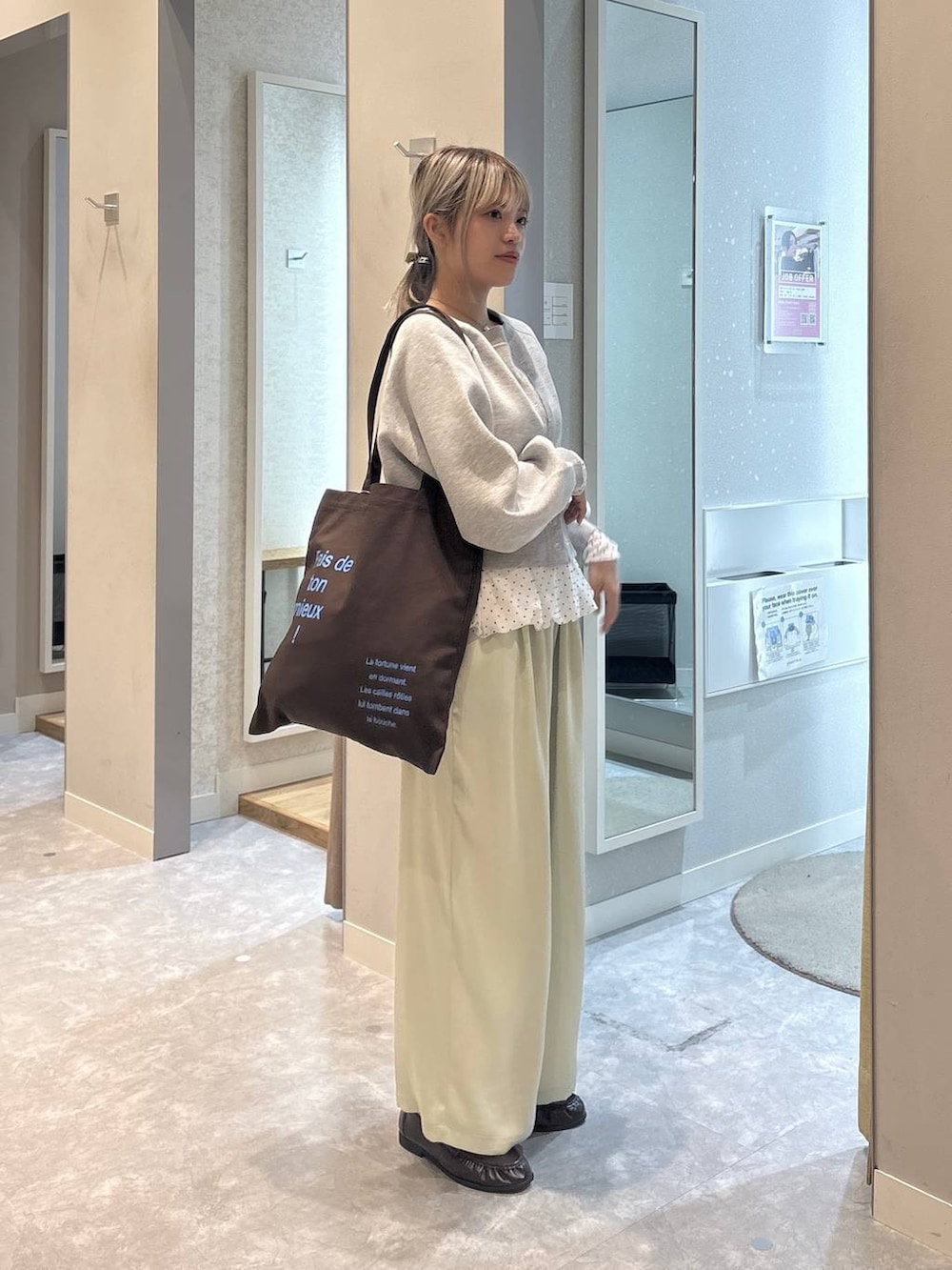 ブラウン系のトートバッグ、ブラウン系のローファー、グリーン系のその他パンツを着用したレディースの冬コーディネートの2枚目の写真