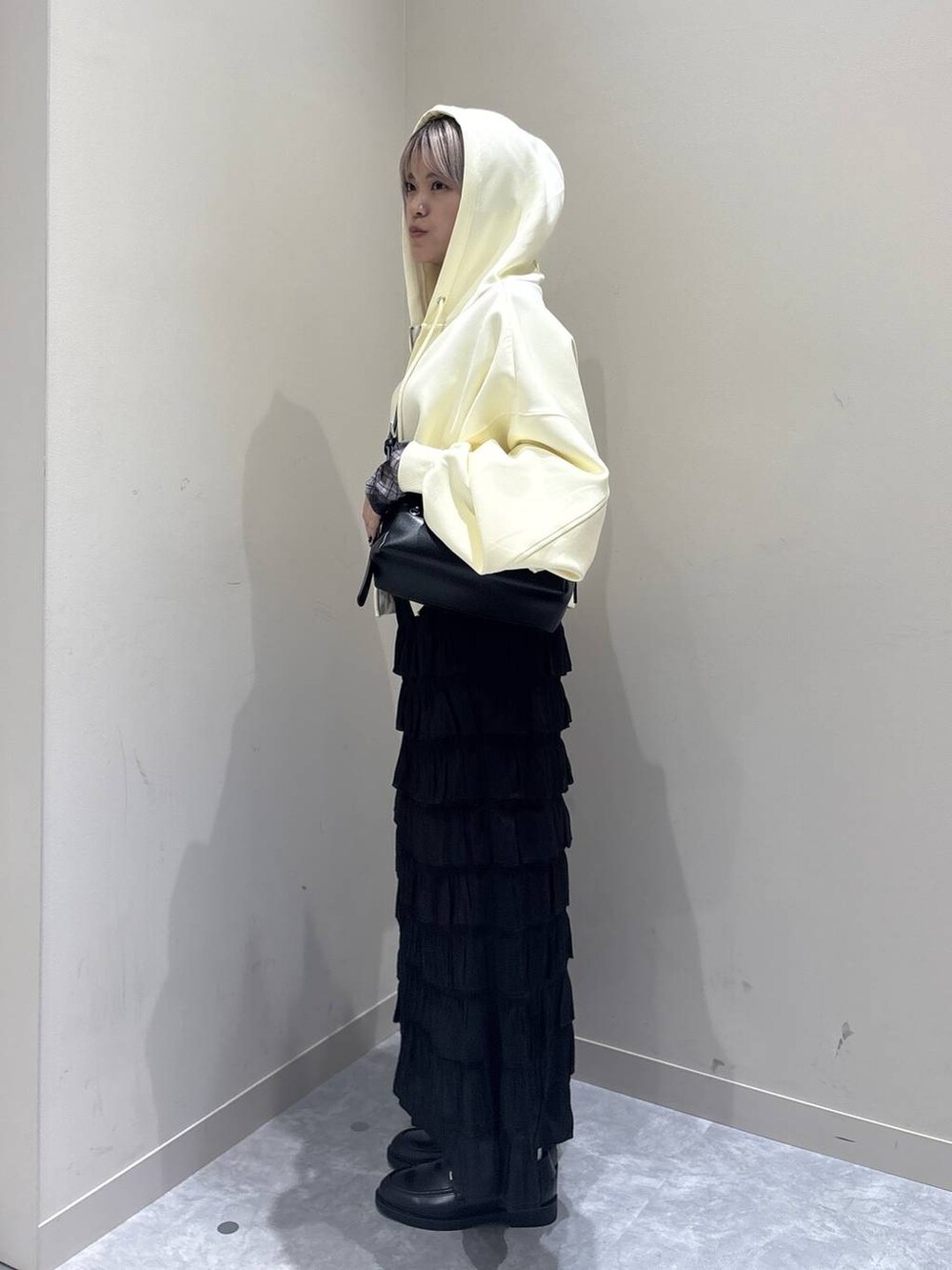 ブラック系のスカート、ブラック系のローファー、イエロー系のパーカーを着用したレディースの秋コーディネートの4枚目の写真