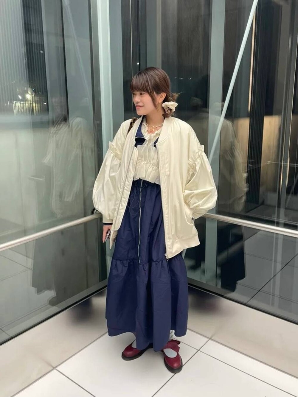 ブルー系のワンピースを着用したレディースの秋コーディネートの2枚目の写真