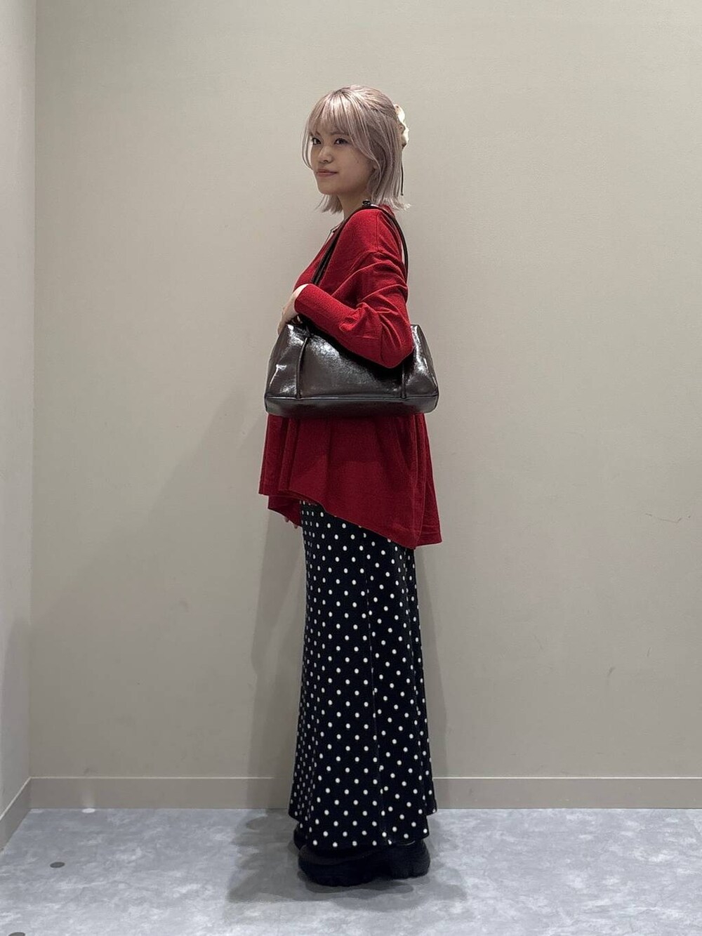 ブラック系のスカート、レッド系のニット/セーター、レッド系のボストンバッグを着用したレディースの秋コーディネートの4枚目の写真