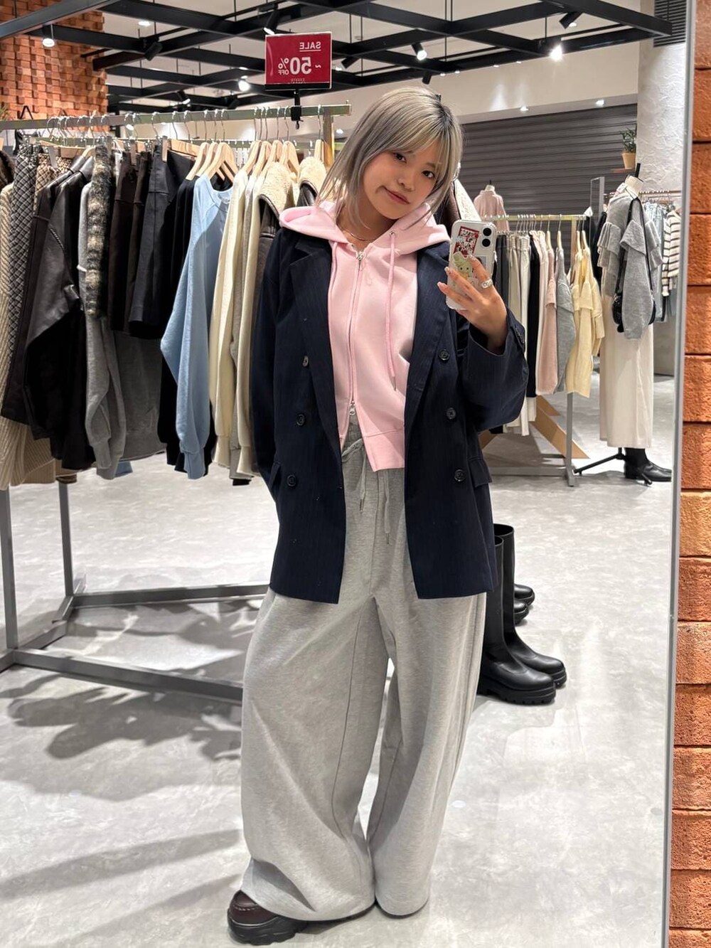 ピンク系のパーカー、ブラウン系のローファー、ブルー系のテーラードジャケットを着用したレディースの春コーディネートの3枚目の写真