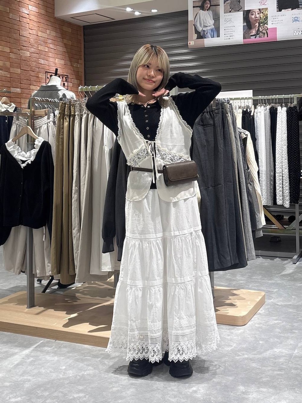 ブラック系のニット/セーター、ブラック系のローファー、ホワイト系のベストを着用したレディースの春コーディネートの5枚目の写真