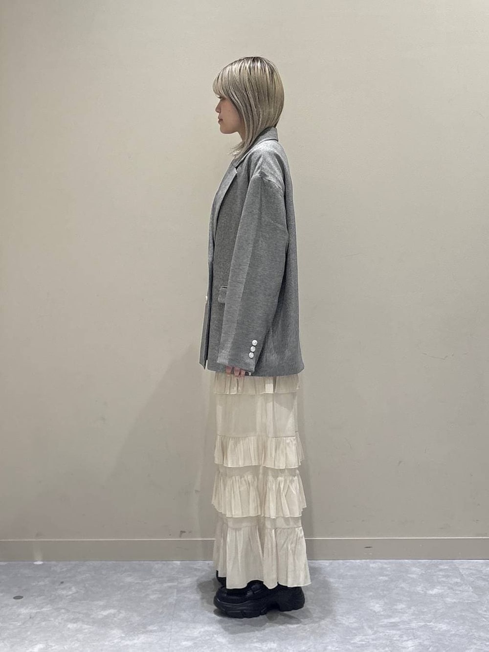 グレー系のテーラードジャケット、ブラック系のローファー、ブルー系のTシャツ/カットソーを着用したレディースの春コーディネートの2枚目の写真