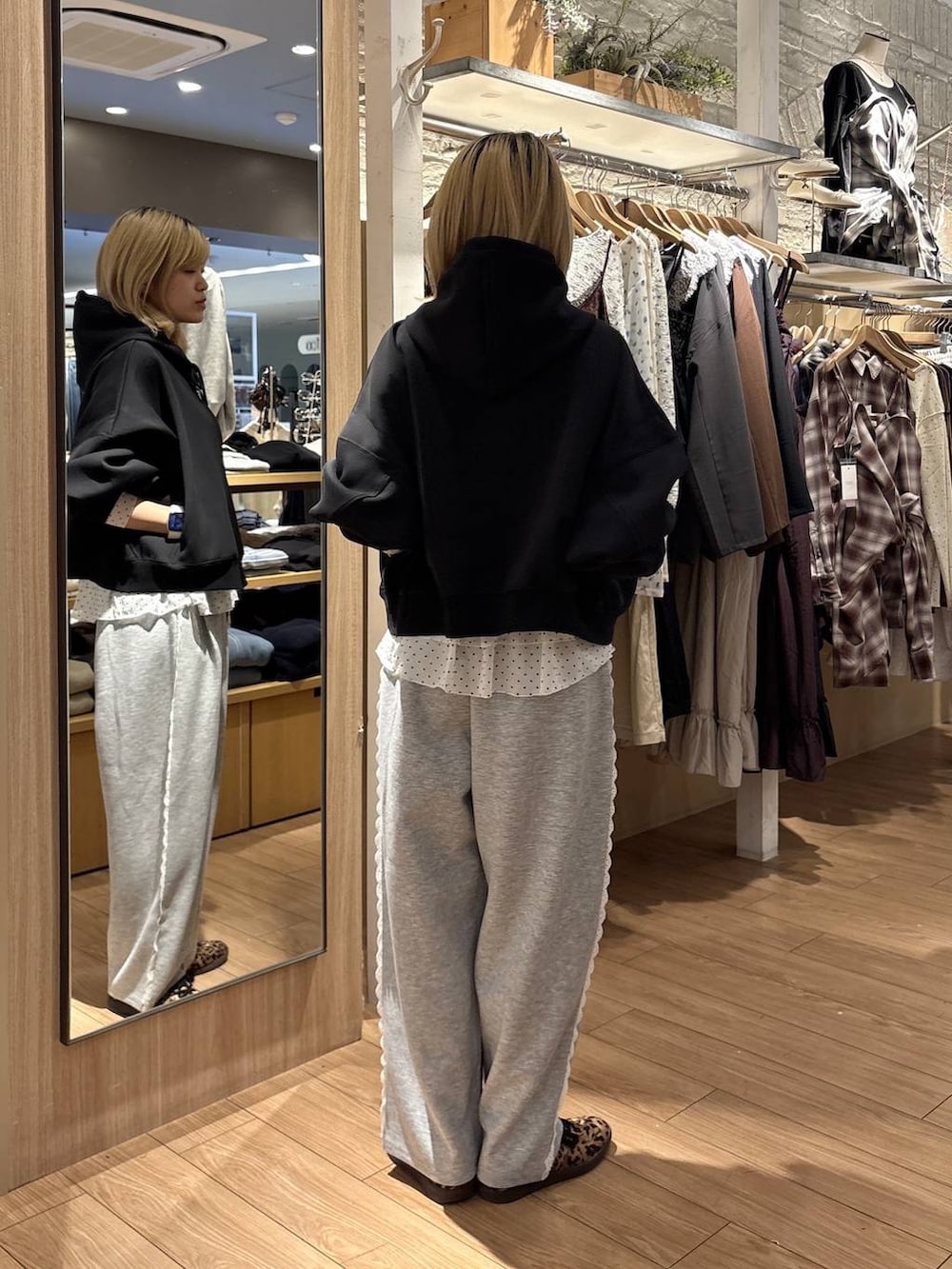 ホワイト系のTシャツ/カットソー、グレー系のスウェットパンツ、ブラック系のパーカーを着用したレディースの秋コーディネートの2枚目の写真