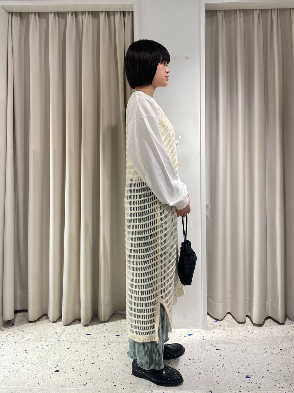 グリーン系のスカート、ブラック系のショルダーバッグ、ブラック系のローファーを着用したレディースの秋コーディネートの2枚目の写真