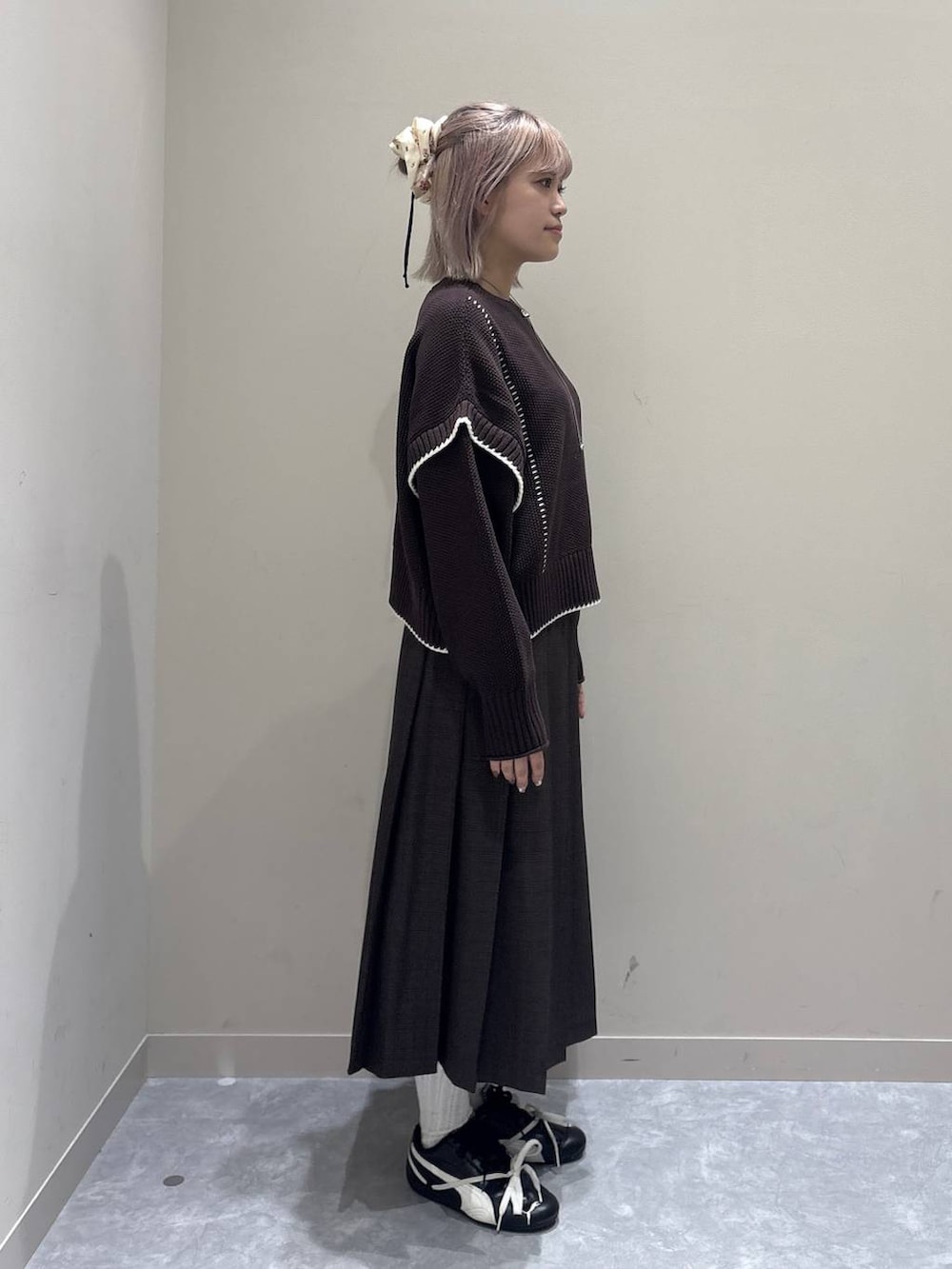 ブラウン系のニット/セーター、ブラウン系のスカートを着用したレディースの秋コーディネートの2枚目の写真