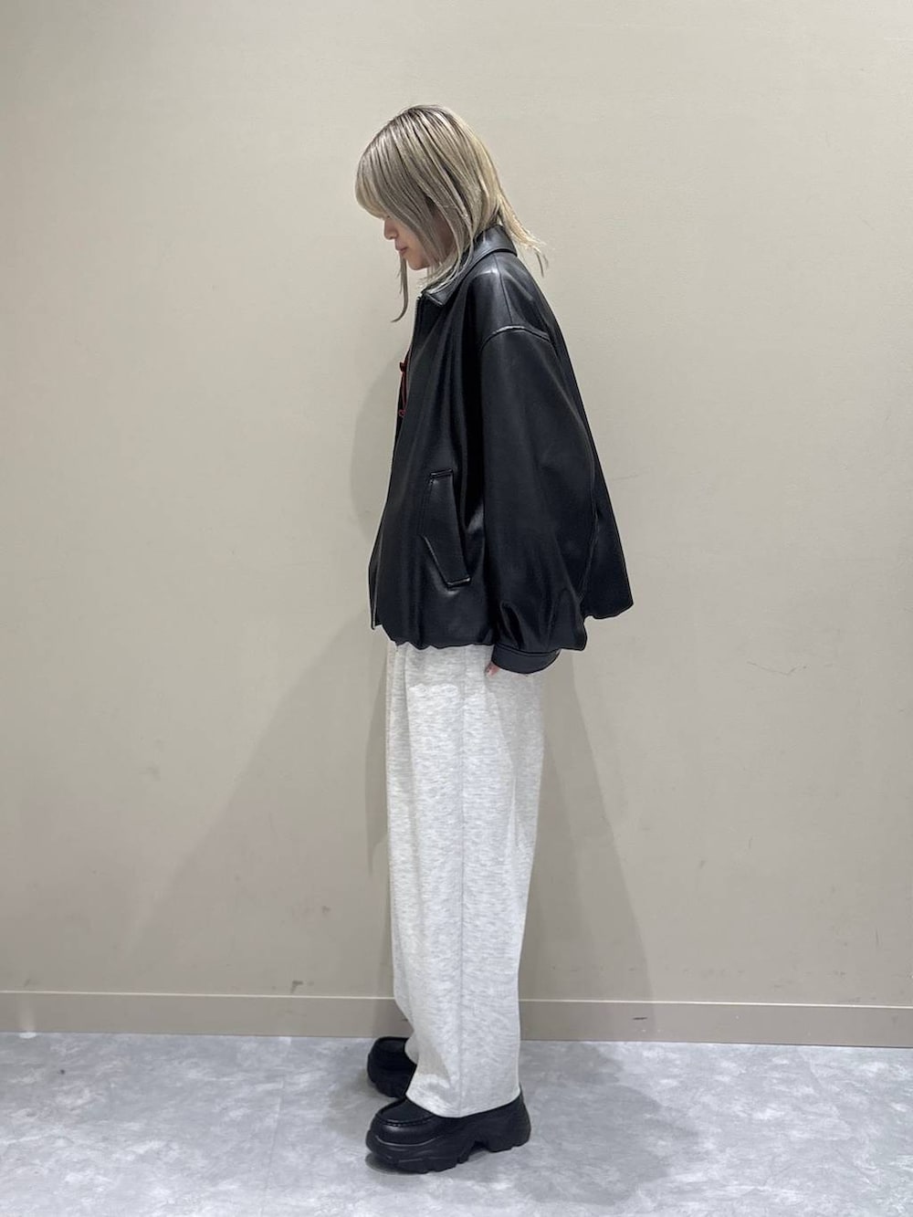 グレー系のスウェットパンツ、ホワイト系のブルゾン、ブラック系のローファーを着用したレディースの春コーディネートの2枚目の写真