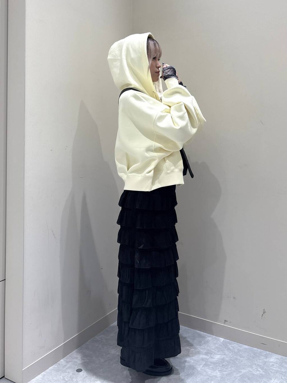 ブラック系のスカート、ブラック系のローファー、イエロー系のパーカーを着用したレディースの秋コーディネートの2枚目の写真