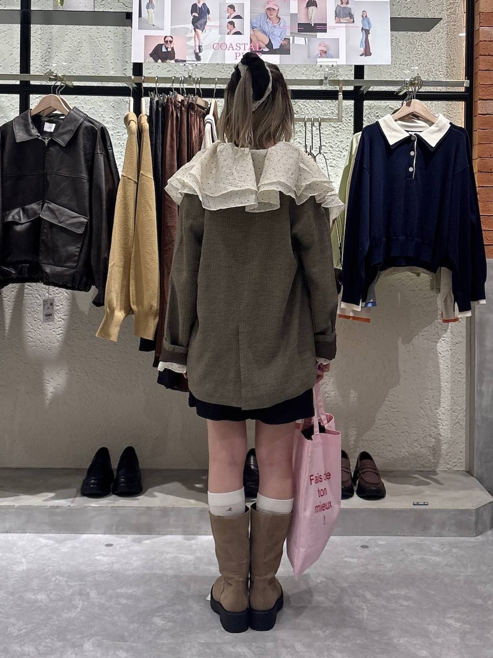 ブラウン系のテーラードジャケット、ベージュ系のブーツ、ピンク系のトートバッグを着用したレディースの春コーディネートの3枚目の写真