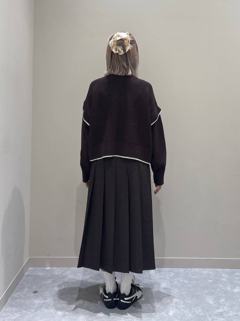 ブラウン系のニット/セーター、ブラウン系のスカートを着用したレディースの秋コーディネートの3枚目の写真