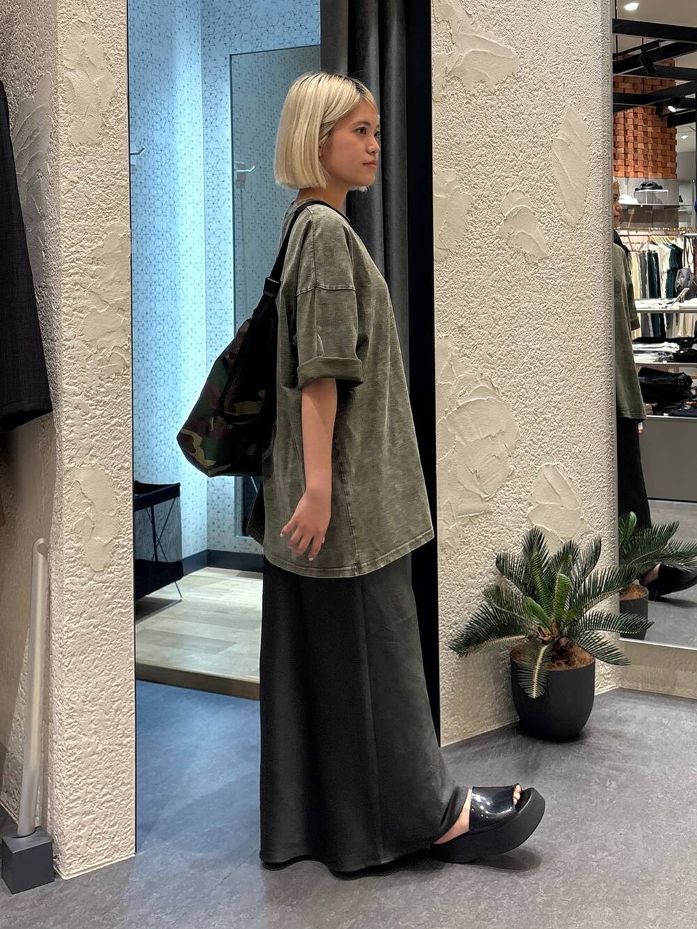 グレー系のスカート、グリーン系のショルダーバッグ、グリーン系のTシャツ/カットソーを着用したレディースの夏コーディネートの4枚目の写真