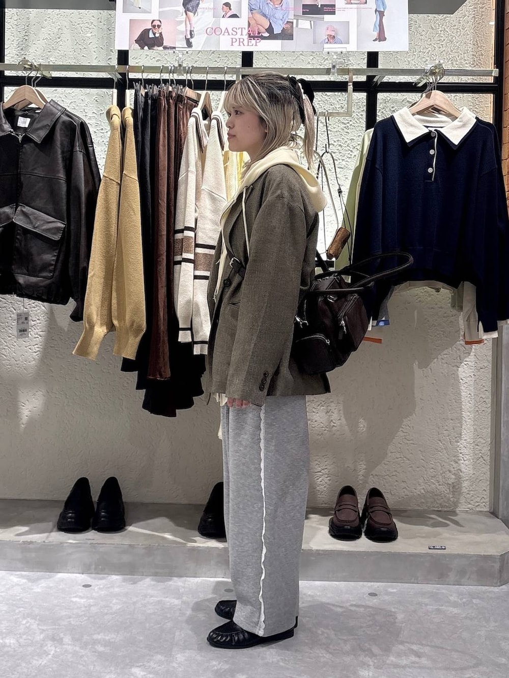 グレー系のスウェットパンツ、イエロー系のパーカー、ブラウン系のテーラードジャケットを着用したレディースの春コーディネートの2枚目の写真