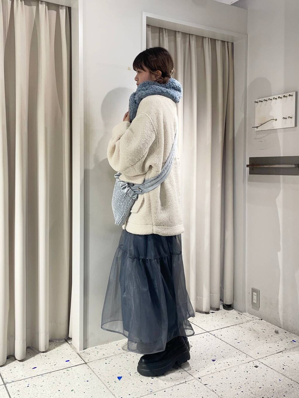 ホワイト系のTシャツ/カットソー、ブラック系のブーツ、ホワイト系のブルゾンを着用したレディースの冬コーディネートの2枚目の写真