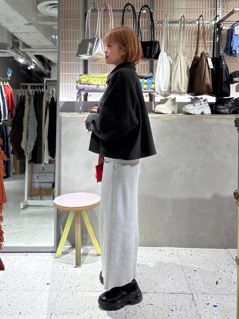 グレー系のスカート、ブラック系のブーツ、ホワイト系のTシャツ/カットソーを着用したレディースの冬コーディネートの4枚目の写真