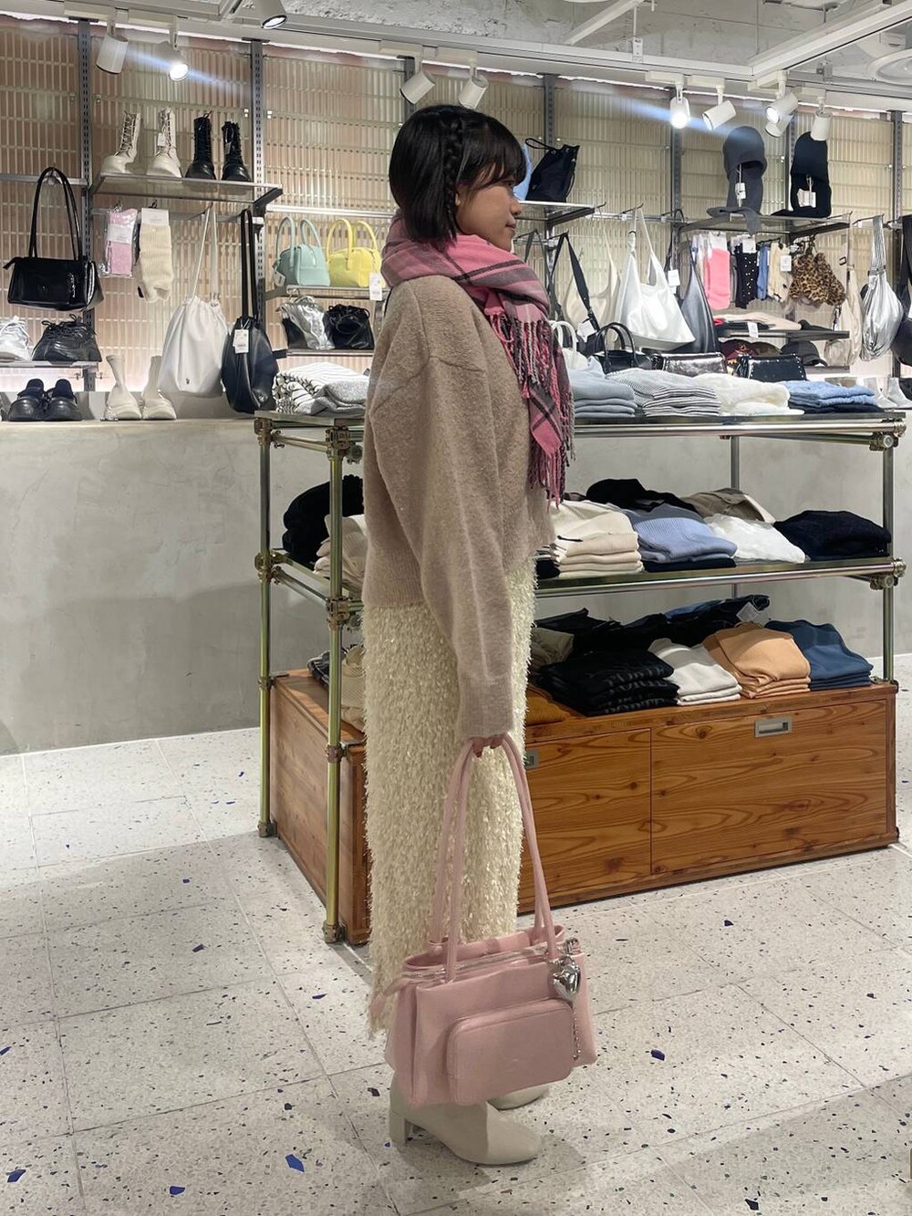 ピンク系のショルダーバッグ、ホワイト系のブーツ、ホワイト系のニット/セーターを着用したレディースの秋コーディネートの2枚目の写真