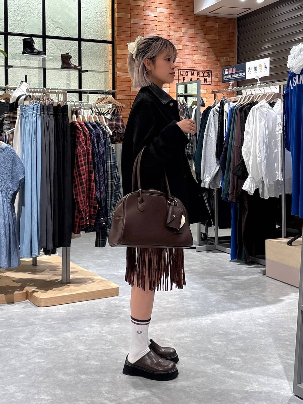 ブラック系のブルゾン、ブラウン系のスカート、ブラウン系のサンダルを着用したレディースの秋コーディネートの4枚目の写真