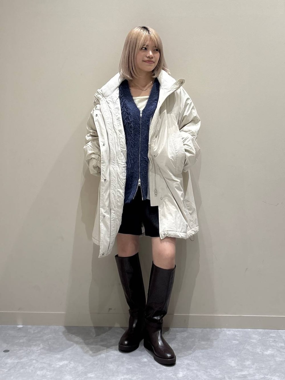 ブルー系のカーディガン/ボレロ、ホワイト系のブルゾン、ブラウン系のブーツを着用したレディースの秋コーディネートの5枚目の写真