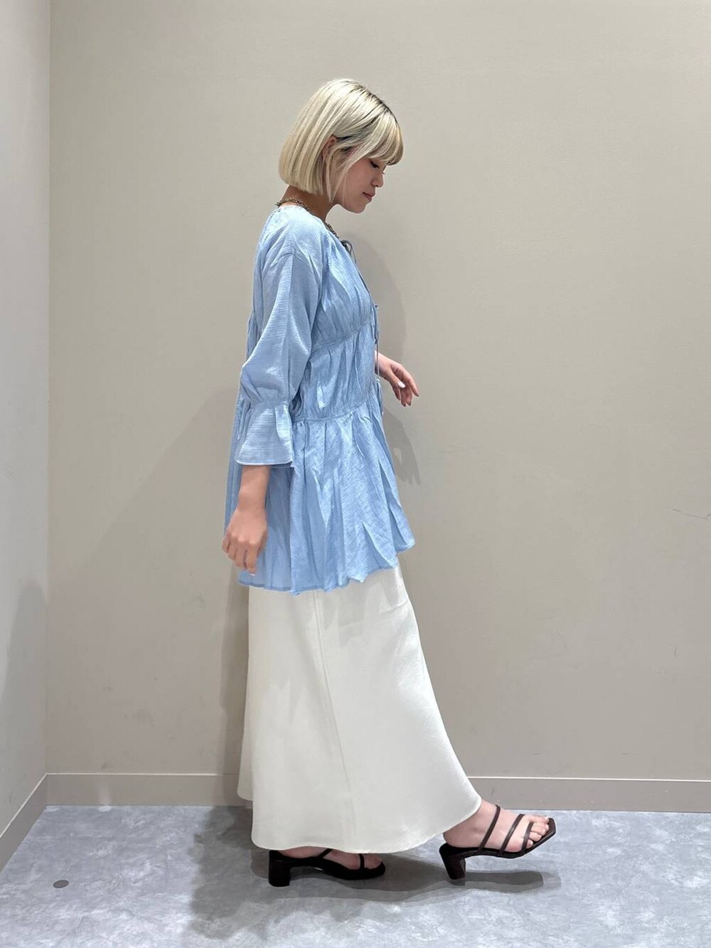 ブルー系のシャツ/ブラウス、ホワイト系のスカート、ブラウン系のサンダルを着用したレディースの夏コーディネートの4枚目の写真