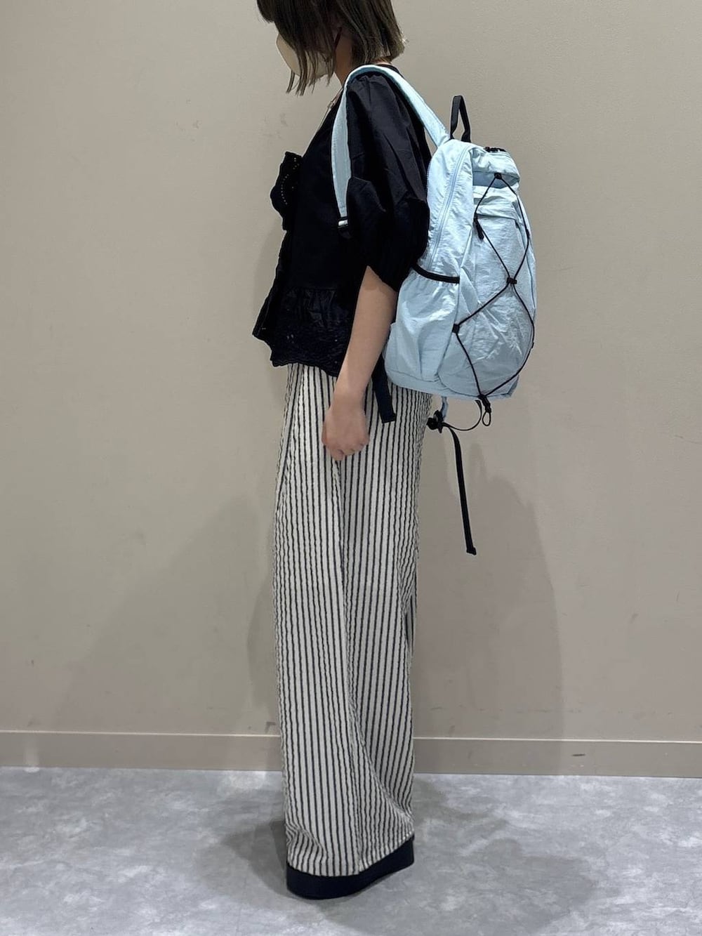 シルバー系のサンダル、ブラック系のシャツ/ブラウス、ブルー系のバックパック/リュックを着用したレディースの春コーディネートの2枚目の写真