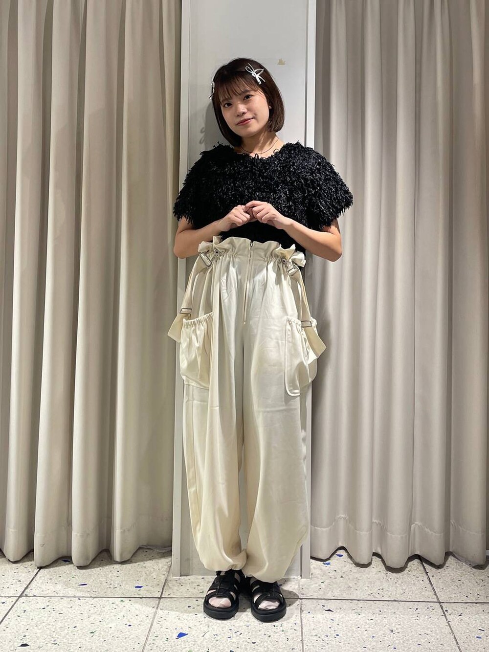 ホワイト系のワンピース、ブラック系のスニーカー、ブラック系のカーディガン/ボレロを着用したレディースの秋コーディネートの3枚目の写真