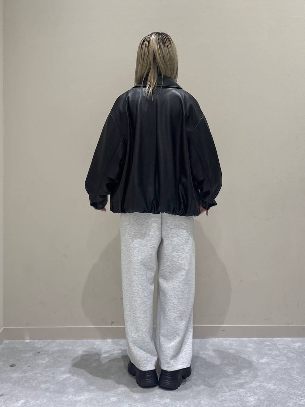 グレー系のスウェットパンツ、ホワイト系のブルゾン、ブラック系のローファーを着用したレディースの春コーディネートの3枚目の写真