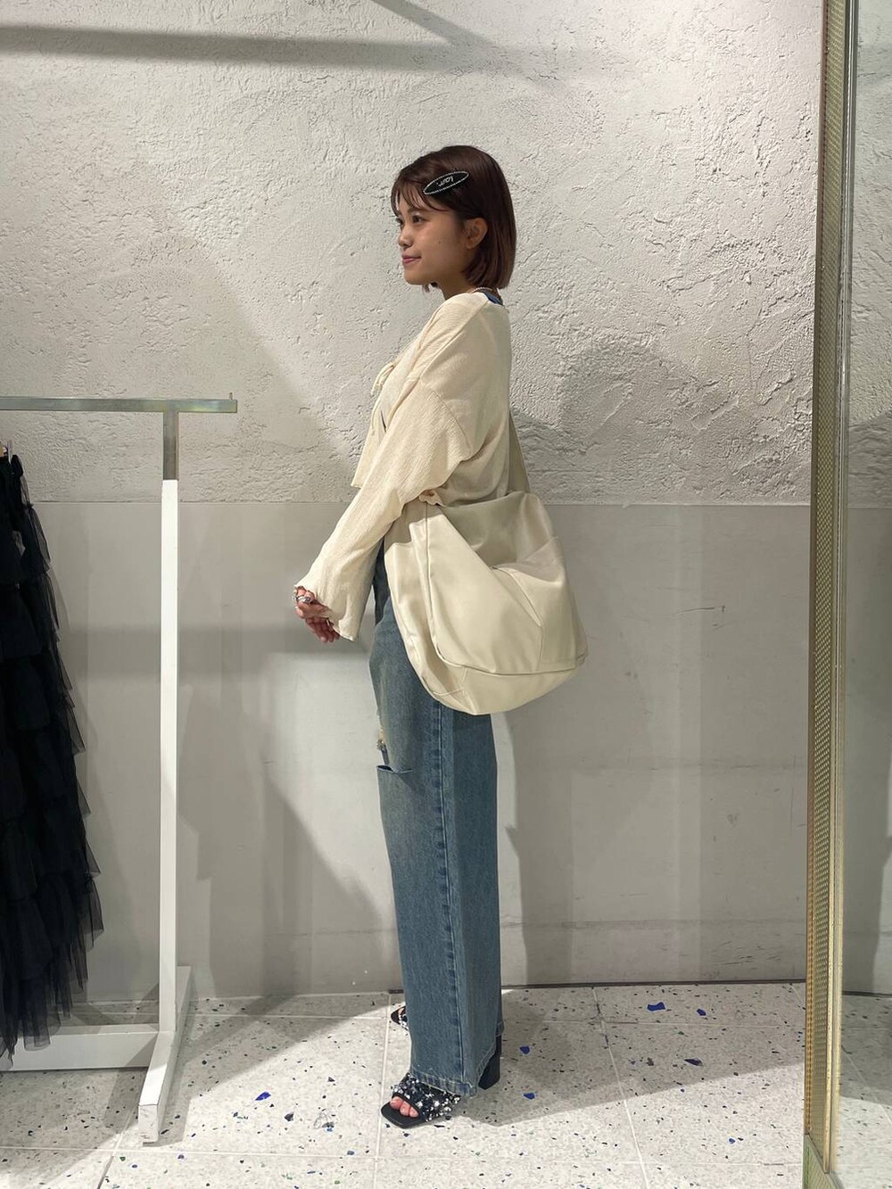 シルバー系のサンダル、ホワイト系のボディバッグ/ウエストポーチ、ブルー系のタンクトップを着用したレディースの夏コーディネートの2枚目の写真