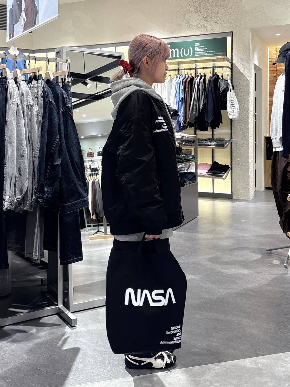 グレー系のスカート、グレー系のTシャツ/カットソー、ブラック系のブルゾンを着用したレディースの秋コーディネートの5枚目の写真