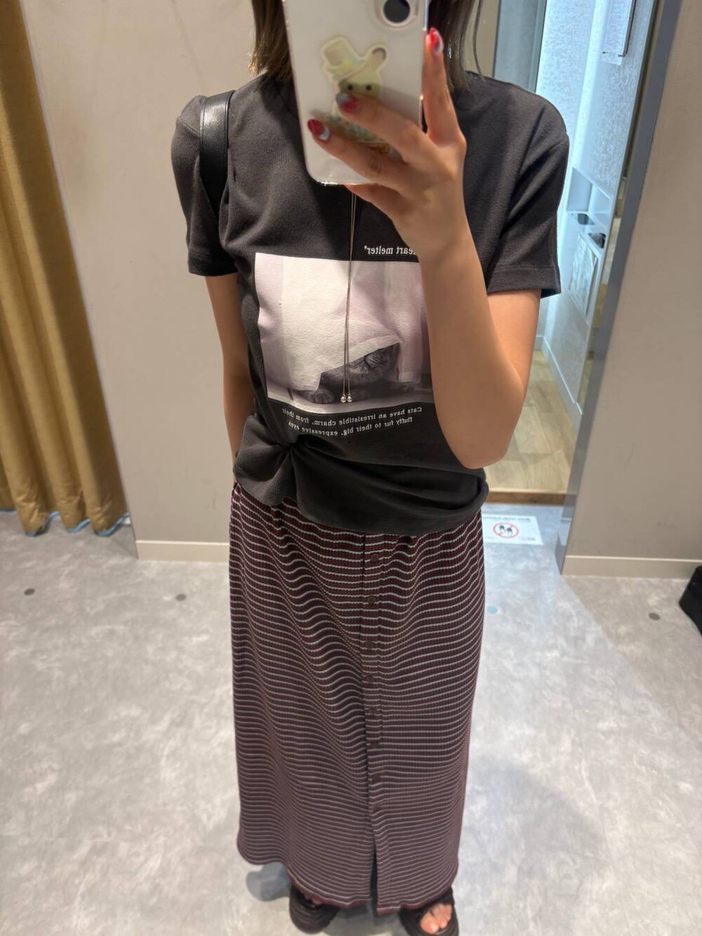 グレー系のTシャツ/カットソー、ブラック系のショルダーバッグ、ブラウン系のサンダルを着用したレディースの夏コーディネートの5枚目の写真