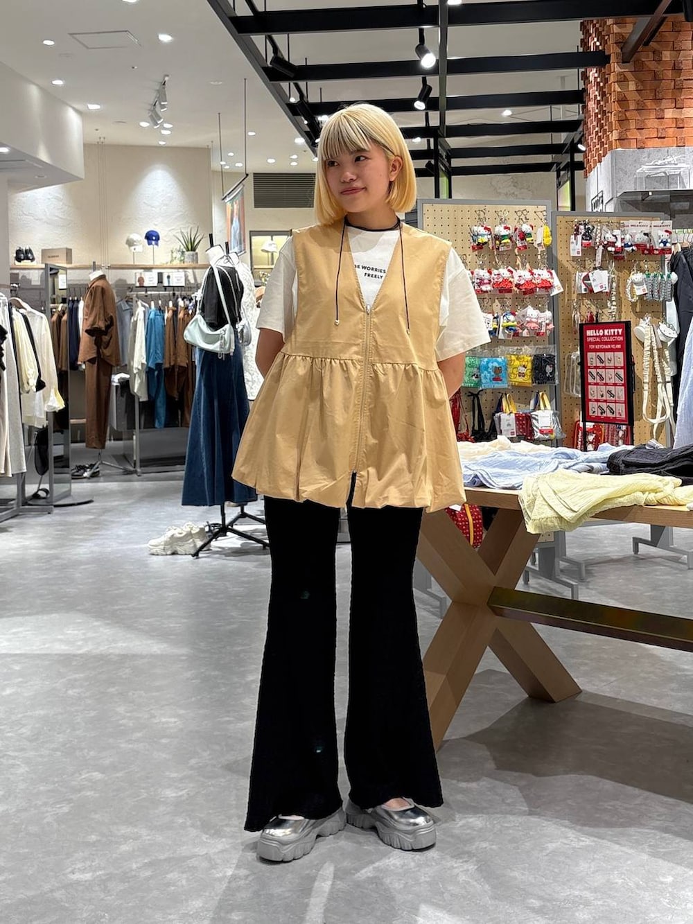 グレー系のスニーカー、ホワイト系のTシャツ/カットソー、ベージュ系のベストを着用したレディースの春コーディネートの5枚目の写真