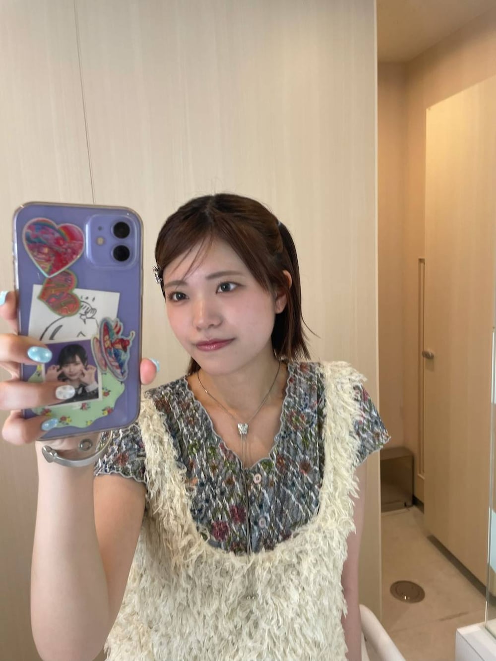 ホワイト系のベスト、グレー系のネックレスを着用したレディースの夏コーディネートの2枚目の写真