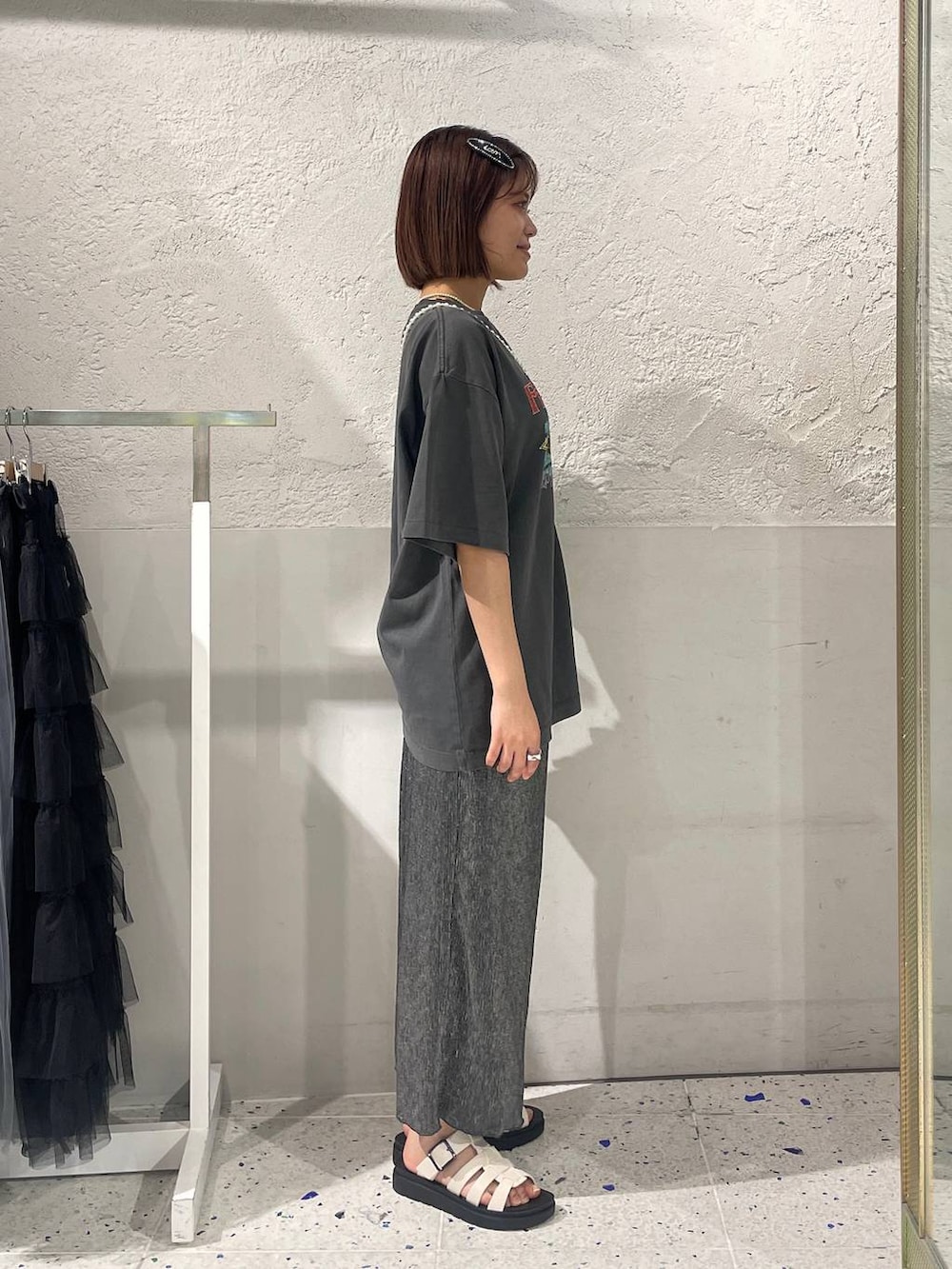 ホワイト系のスニーカー、グレー系のTシャツ/カットソー、ブラック系のスカートを着用したレディースの夏コーディネートの2枚目の写真