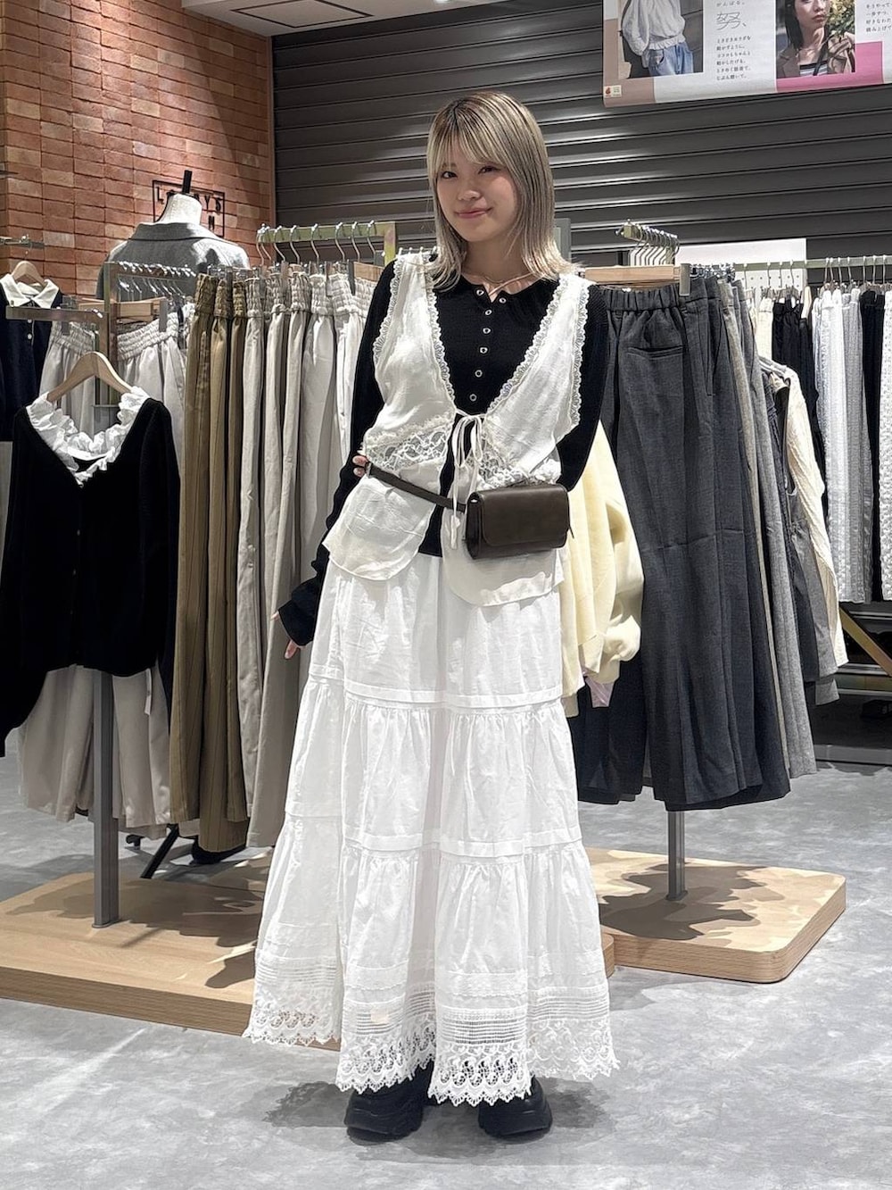 ブラック系のニット/セーター、ブラック系のローファー、ホワイト系のベストを着用したレディースの春コーディネートの6枚目の写真