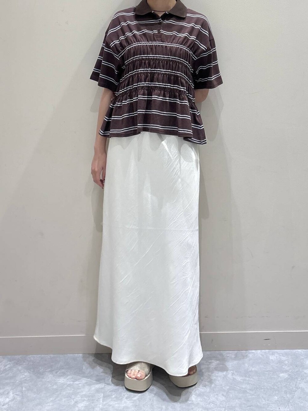 ホワイト系のスカート、ホワイト系のサンダル、ブラウン系のTシャツ/カットソーを着用したレディースの夏コーディネートの4枚目の写真