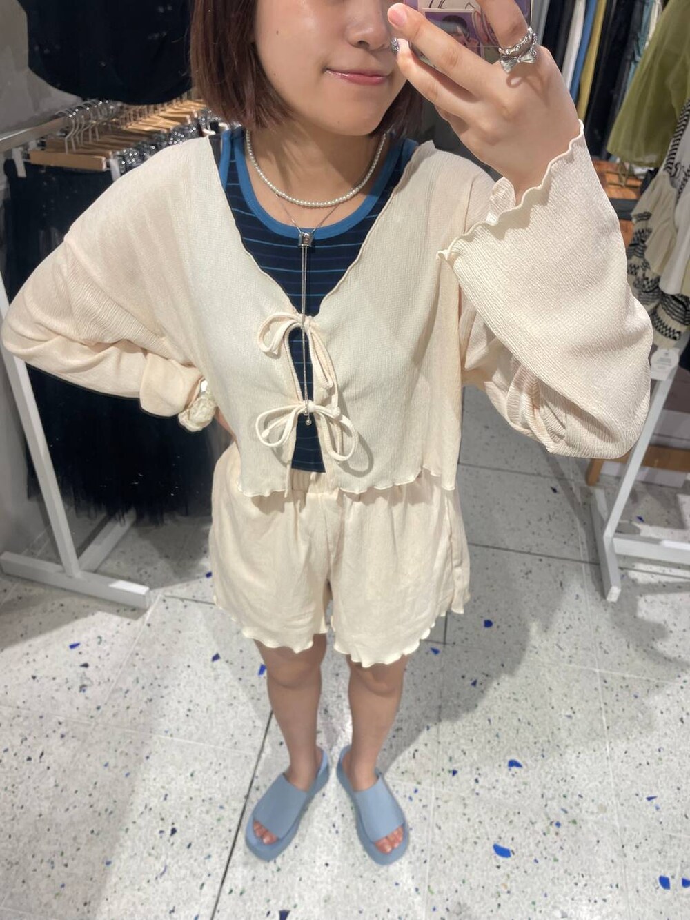 ブルー系のショルダーバッグ、ブルー系のサンダル、ブルー系のタンクトップを着用したレディースの春コーディネートの6枚目の写真