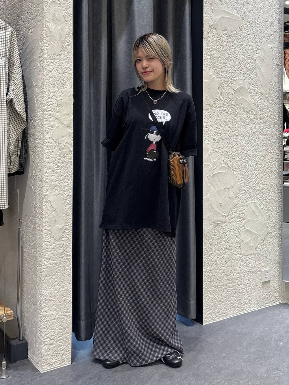 ブラウン系のショルダーバッグ、グレー系のスカート、ブラック系のTシャツ/カットソーを着用したレディースの春コーディネートの5枚目の写真