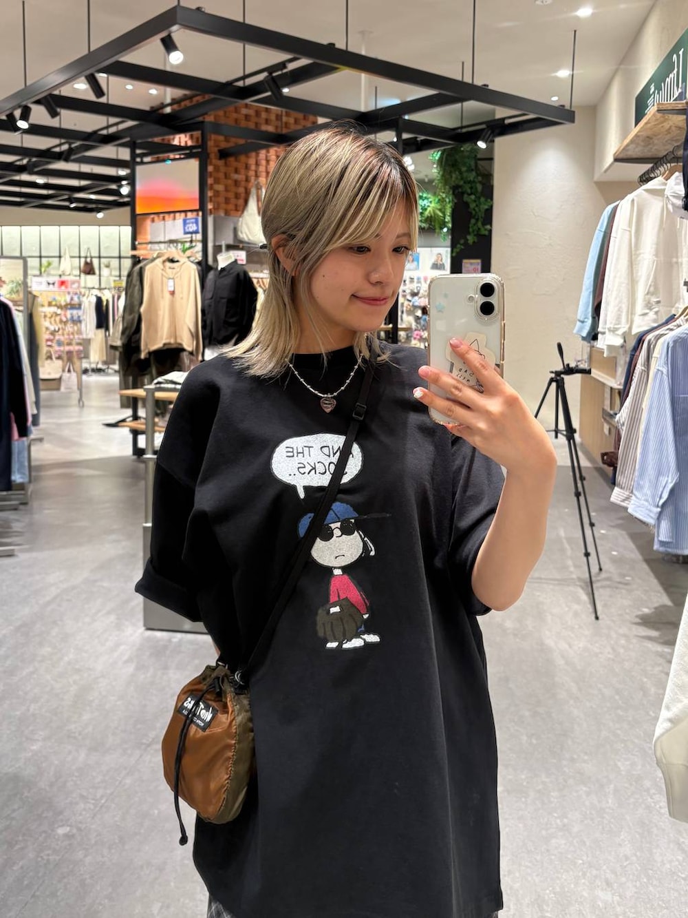 ブラウン系のショルダーバッグ、グレー系のスカート、ブラック系のTシャツ/カットソーを着用したレディースの春コーディネートの6枚目の写真