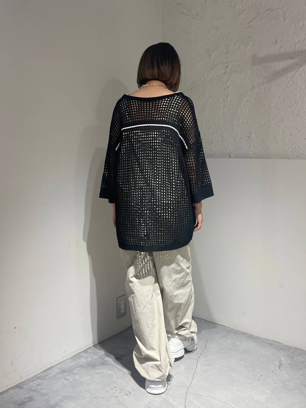 ホワイト系のサンダル、ホワイト系のサロペット/オーバーオール、ブラック系のニット/セーターを着用したレディースの春コーディネートの3枚目の写真