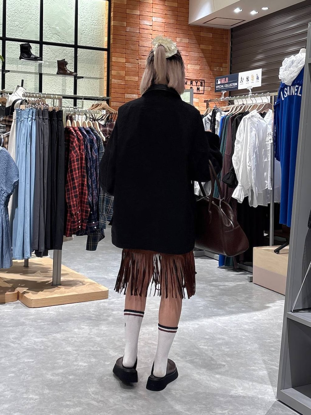 ブラック系のブルゾン、ブラウン系のスカート、ブラウン系のサンダルを着用したレディースの秋コーディネートの3枚目の写真