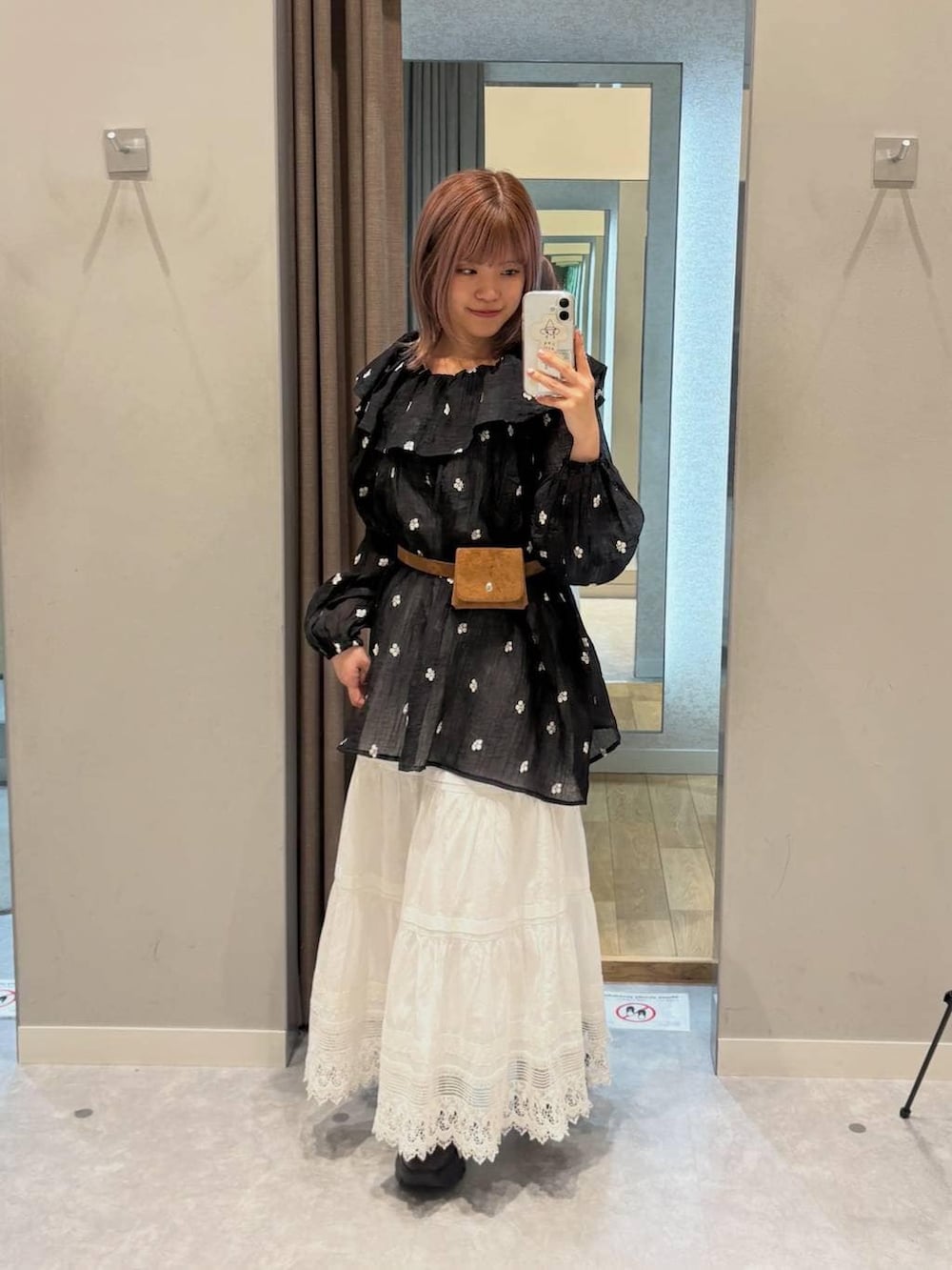 ブラウン系のローファー、ホワイト系のスカート、ブラック系のワンピースを着用したレディースの春コーディネートの7枚目の写真