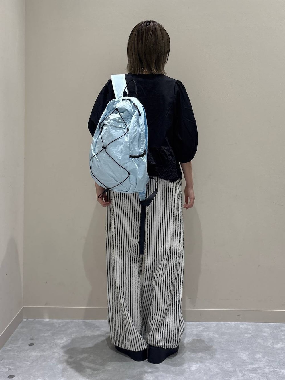シルバー系のサンダル、ブラック系のシャツ/ブラウス、ブルー系のバックパック/リュックを着用したレディースの春コーディネートの3枚目の写真
