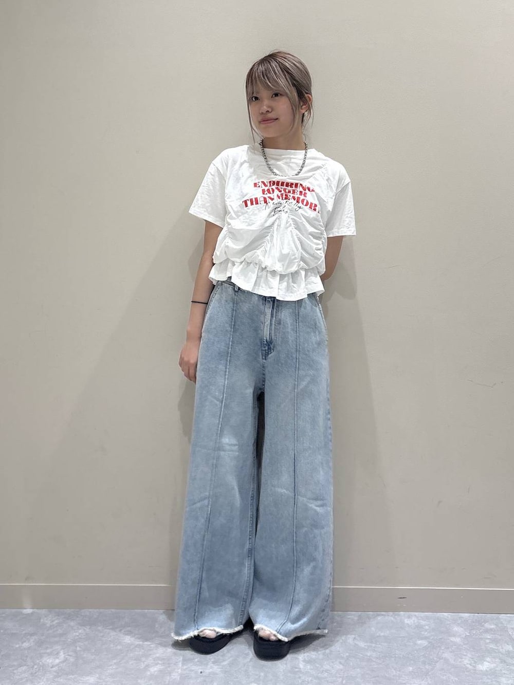 ブルー系のデニムパンツ、シルバー系のサンダル、ホワイト系のTシャツ/カットソーを着用したレディースの春コーディネートの5枚目の写真