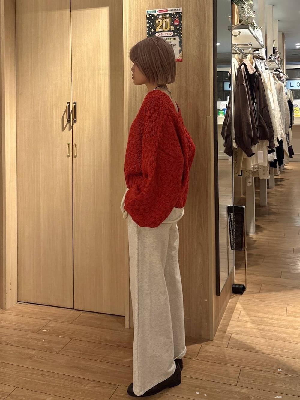 ホワイト系のスウェットパンツ、ブラウン系のローファー、レッド系のカーディガン/ボレロを着用したレディースの秋コーディネートの2枚目の写真