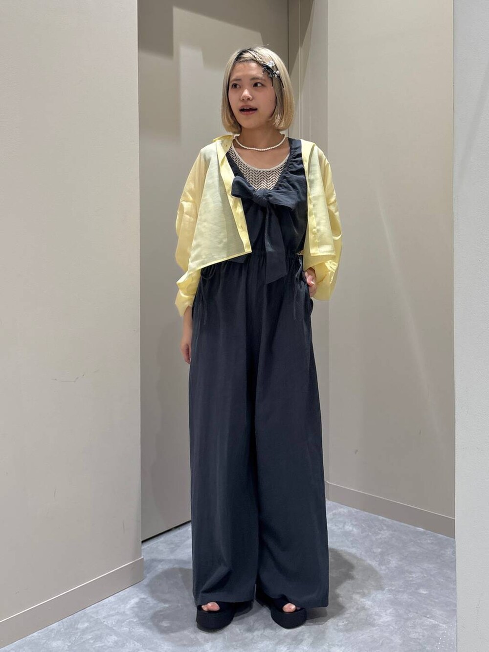 ホワイト系のTシャツ/カットソー、イエロー系のシャツ/ブラウス、ブラック系のサンダルを着用したレディースの春コーディネートの5枚目の写真