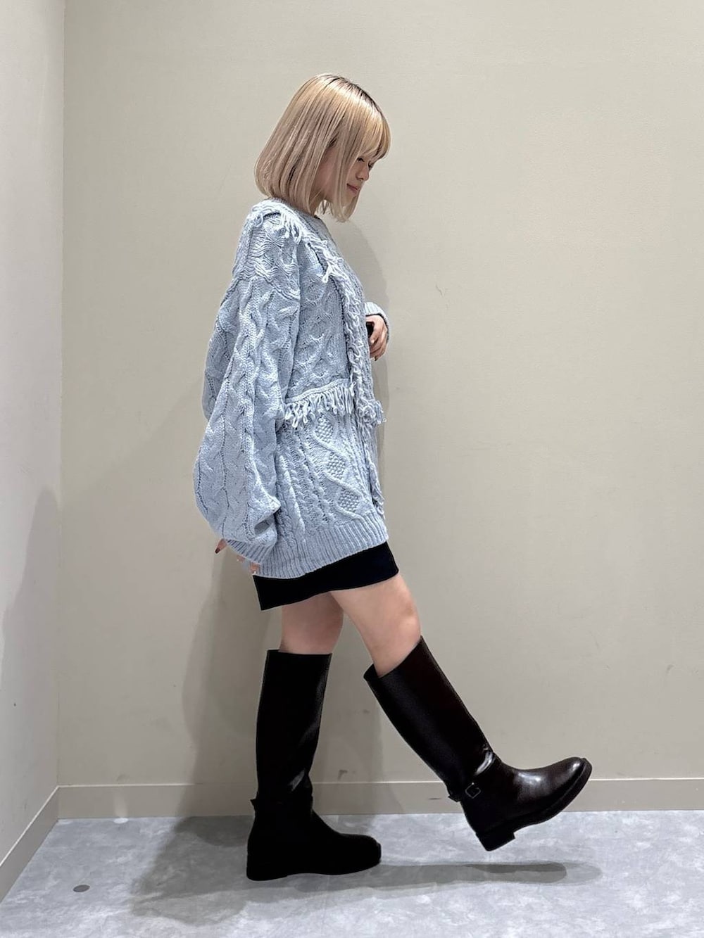 グレー系のその他パンツ、ブルー系のニット/セーター、ブラウン系のブーツを着用したレディースの冬コーディネートの4枚目の写真