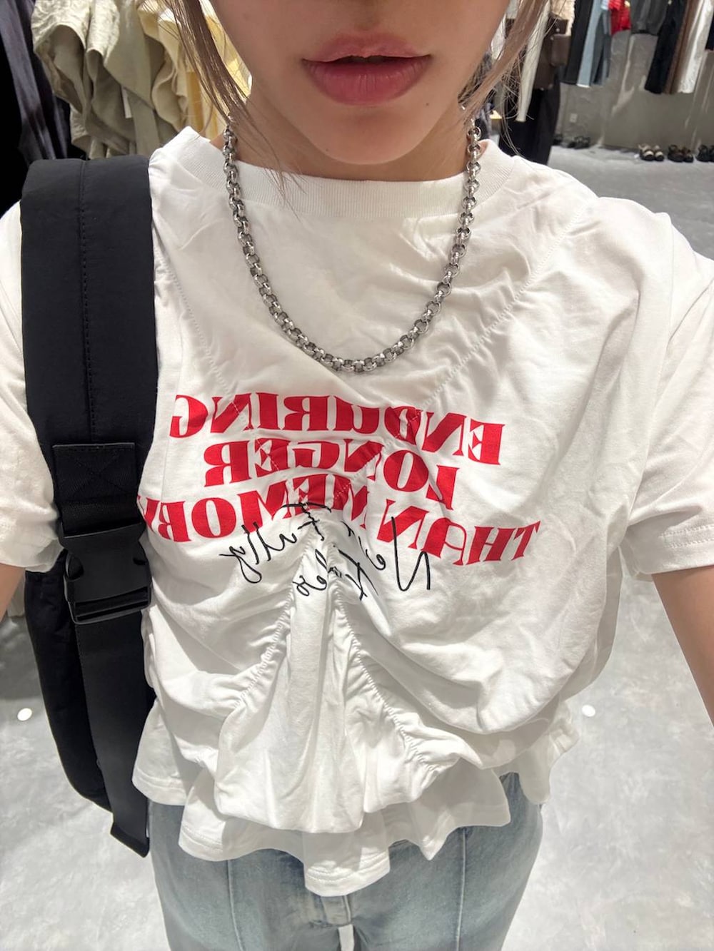 ブルー系のデニムパンツ、シルバー系のサンダル、ホワイト系のTシャツ/カットソーを着用したレディースの春コーディネートの6枚目の写真