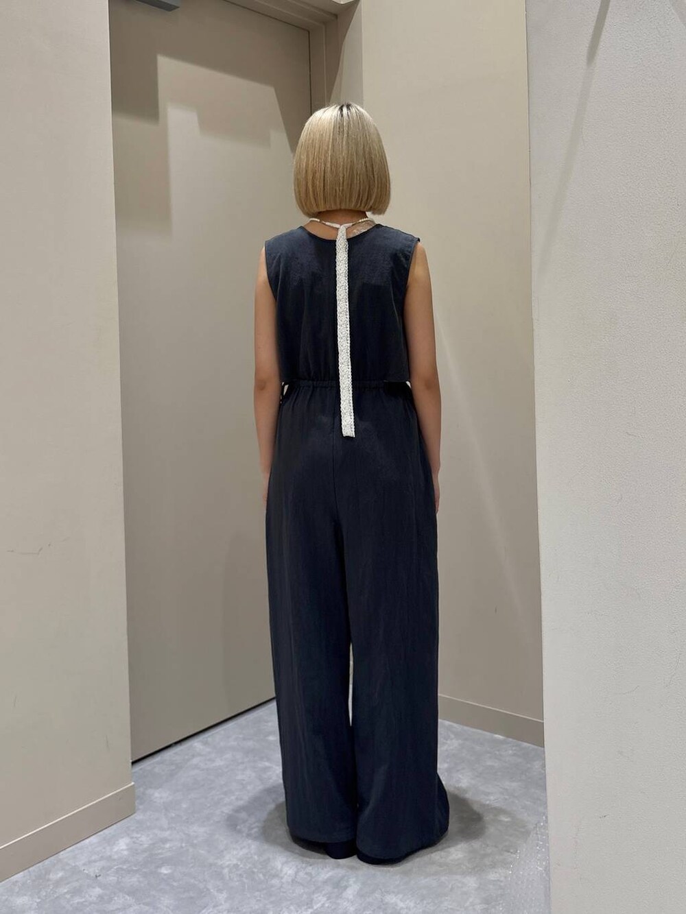 ホワイト系のTシャツ/カットソー、ブラック系のサンダル、グレー系のサロペット/オーバーオールを着用したレディースの春コーディネートの3枚目の写真