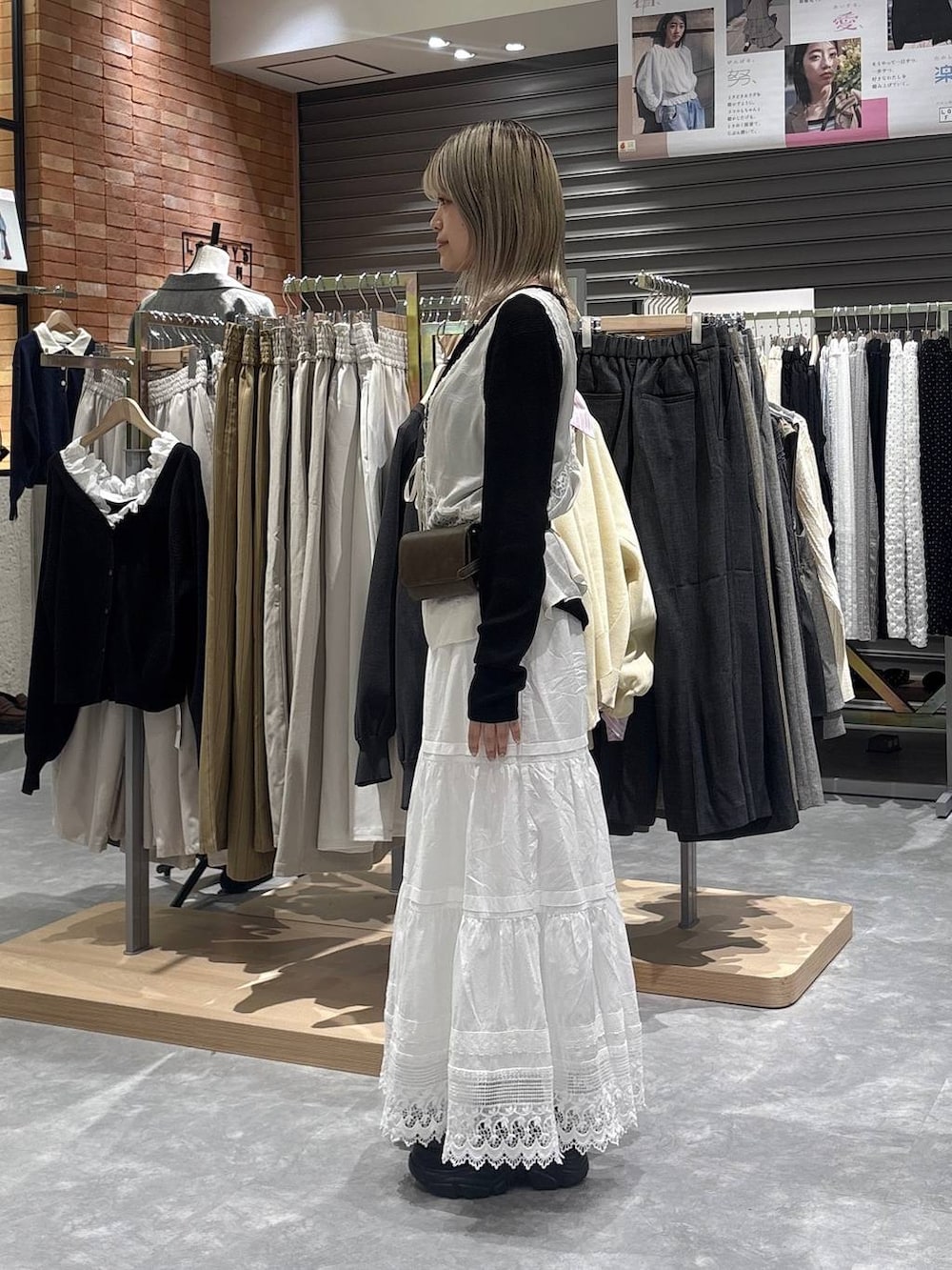 ブラック系のニット/セーター、ブラック系のローファー、ホワイト系のベストを着用したレディースの春コーディネートの2枚目の写真