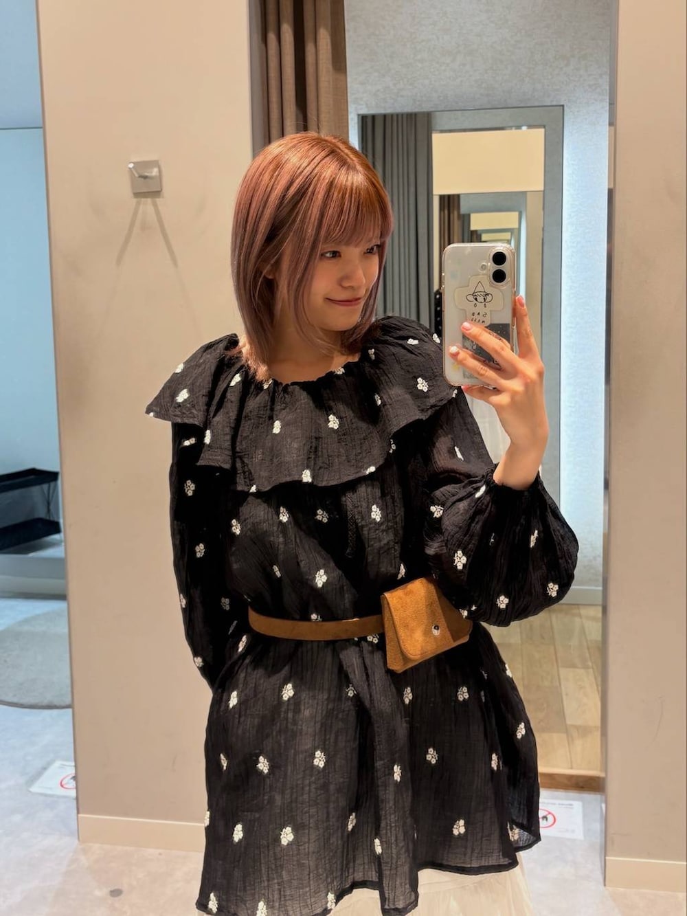 ブラウン系のローファー、ホワイト系のスカート、ブラック系のワンピースを着用したレディースの春コーディネートの6枚目の写真