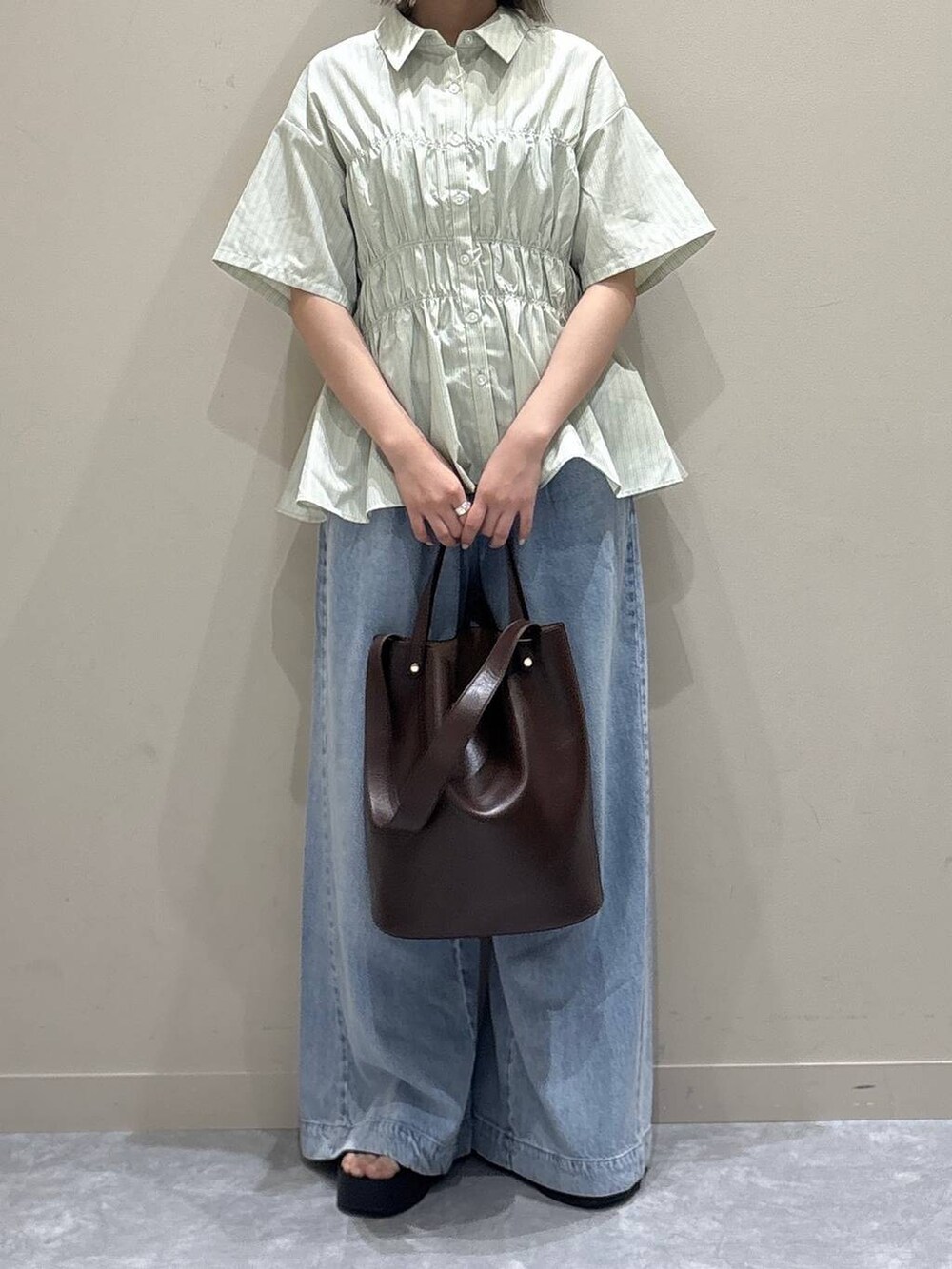 シルバー系のサンダル、ブラウン系のショルダーバッグ、グリーン系のTシャツ/カットソーを着用したレディースの春コーディネートの5枚目の写真